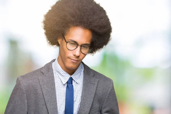 Young african american business man with afro hair wearing glasses with hand on stomach because nausea, painful disease feeling unwell. Ache concept.