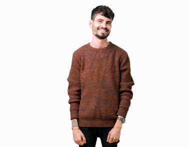 Üzerinde kış kazak giyen genç yakışıklı adam arka plan uzak tarafına gülümseme ile yüzünde, doğal ifade arıyorum izole. Kendine güvenen gülüyor.