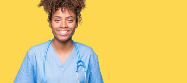 Genç Afro-Amerikan doktor kadın yüzünde mutlu ve güzel bir gülümseme ile izole arka plan yüzünden. Şanslı kişi.