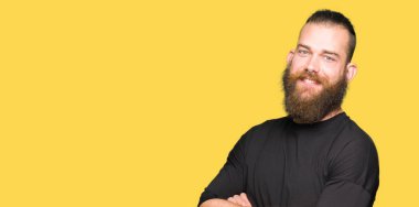 Rahat t-shirt mutlu yüz ile gülümseyen giyen genç sarışın adam kameraya seyir silah geçti. Olumlu bir kişi.