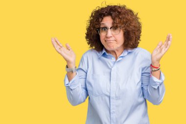Güzel orta ager üst düzey businees kadın üzerinde gözlük takan arka plan clueless ve şaşkın bir ifadeyle kollar ve eller kaldırdı izole. Şüphe kavramı.