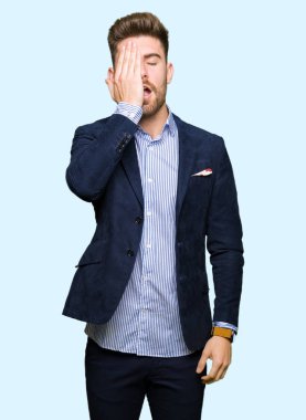 Genç yakışıklı bussines adam yarım yüz, göz ve ağız el ile kapsayan yorgun esneme. Acı yüzü acıyor.