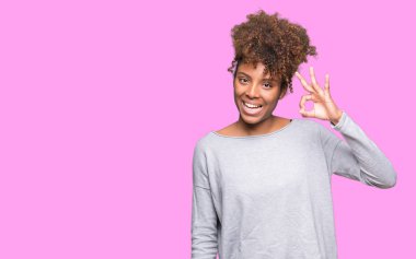 Gülümseyen izole arka plan üzerinde güzel genç Afro-Amerikan kadın el ve parmaklar ok işaretiyle yapıyor olumlu. Başarılı ifade.