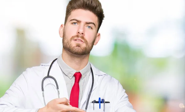 Jovem Bonito Médico Homem Vestindo Casaco Médico Com Pressa Apontando — Fotografia de Stock