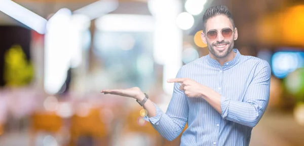 Jonge Knappe Man Dragen Van Een Zonnebril Geïsoleerde Achtergrond Verbaasd — Stockfoto