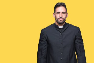 İzole arka plan üzerinde genç Hıristiyan rahip yüzünde ciddi bir ifade ile rahat. Basit ve doğal kamera bakıyor.