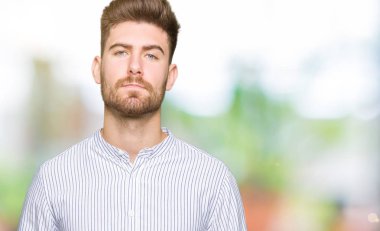 Eller birlikte genç yakışıklı adam ve rahat ve neşeli gülümseyen parmak çarpı işareti. Başarı ve iyimser