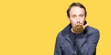 Orta yaş yakışıklı adam güzel ve seksi olmak hava el ile bir öpücük üfleme kamera bakıyor bir ceket giyiyor. Aşk ifadesi.