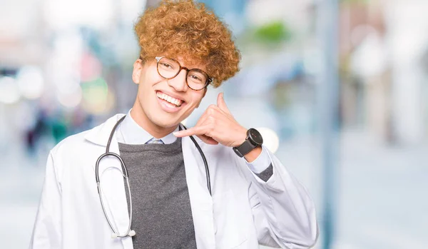 Tânărul Doctor Chipeş Purtând Haină Medicală Zâmbind Făcând Gestul Telefonului — Fotografie, imagine de stoc