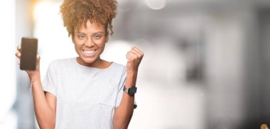Genç Afro-Amerikan kadın gösteren smartphone ekran gurur çığlık ve zafer ve başarı çok heyecanlı, duygu tezahürat kutluyor izole arka plan üzerinde