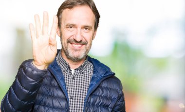 Kış ceket gösterme ve parmakları ile işaret giyen orta yaş yakışıklı adam kendinden emin ve mutlu gülümseyerek süre dört numara.