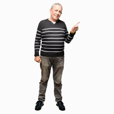 Kameraya bakarak yan el ve parmak ile işaret Kazak yüzünde kocaman bir gülümseme ile üst düzey yakışıklı kış giyen çizgili.