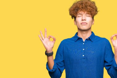 Saç relax afro genç yakışıklı zarif adamla ve gülümseyen gözlerle parmak ile meditasyon jest yapıyor kapalı. Yoga kavramı.