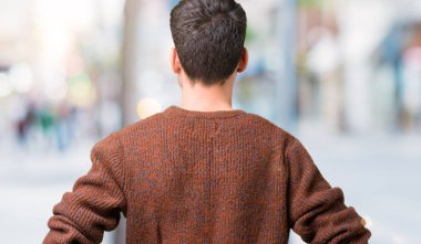 İzole arka plan ayakta geriye doğru uzakta silah ile vücut üzerinde seyir üzerinde kış kazak giyen genç yakışıklı adam