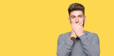 Çizgili süveter ağız hata için elleriyle kapsayan şok giyen genç yakışıklı adam. Gizli kavramı.