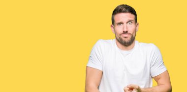 Yakışıklı adam acele işaretleme izlemek için zaman, sabırsızlık, üzgün ve kızgın son tarih gecikme için rahat beyaz t-shirt giyen