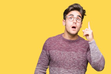 Başarılı fikirle izole arka plan işaret parmağı üzerinde gözlük takan yakışıklı delikanlı. Çıktıktan ve mutlu. Bir numara.