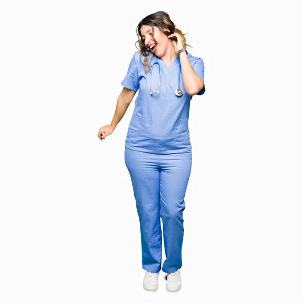 医療ユニフォームを着た若い大人の医者の女性は幸せで陽気な踊り 笑顔のカジュアルで自信に満ちた音楽を聴く — ストック写真