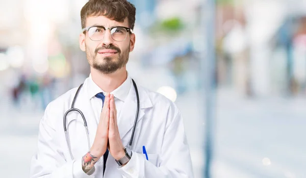 Joven Médico Con Abrigo Hospital Sobre Fondo Aislado Mendigando Rezando — Foto de Stock