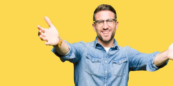 Hombre Guapo Con Gafas Mirando Cámara Sonriendo Con Los Brazos —  Fotos de Stock