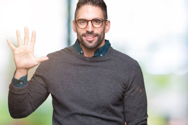 Gösterilen arka plan üzerinde gözlük takan genç yakışıklı adam izole ve parmakları ile işaret kendinden emin ve mutlu gülümseyerek süre beş numara.