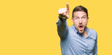 Yakışıklı iş adamı mavi gözleri işaret parmağı ile devam sürpriz, açık ağız hayret ifadesi, önünde bir şey