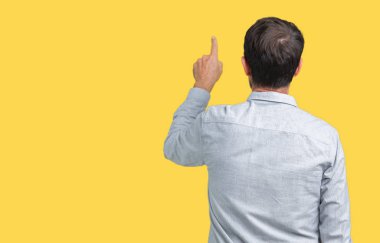 Yakışıklı orta yaş zarif komuta sizde gözlük izole üzerinden geriye doğru arkasında parmak eliyle işaret Posing arka plan