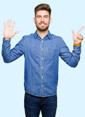 Gösterilen ve parmakları ile işaret rahat kot gömlek giymiş genç yakışıklı sarışın adam kendinden emin ve mutlu gülümseyerek süre yedi numara.