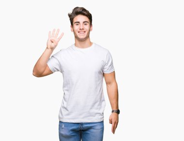 Yakışıklı delikanlı gösterilen ve parmakları ile işaret izole arka plan üzerinde beyaz t-shirt giyen süre kendinden emin ve mutlu gülümseyerek dört numara.