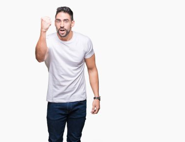 Öfkeli ve sinirli sinirli ve öfke ile bağırarak süre öfkeli yumruk yükselterek izole arka plan üzerinde rahat beyaz t-shirt giyen genç adam. Öfke ve agresif kavramı.