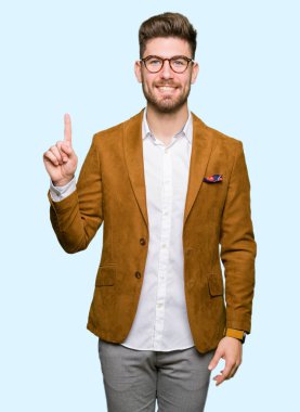 Gösterilen ve parmak gülümseyen süre bir numara ile kendinden emin ve mutlu yukarıyı gözlüklü genç yakışıklı iş adamı.