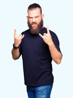 Deli ifade rock simge elle yapıyor ile rahat t-shirt bağırarak giyen genç sarışın adam. Müzik yıldızı. Ağır kavramı.