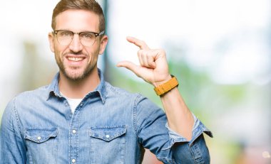 Gülümseyen bardakları ve süre seyir ve kamera boyutu işaret parmaklarıyla yapıyor el ile kendine güvenen el hareketi giyen yakışıklı adam. Ölçü kavramı.