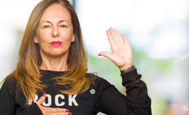 Rock'n roll kazak giyen güzel orta yaş kadın göğüs ve bir sadakat sözü yemin yapma avuç, el ile küfür