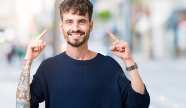 Yakışıklı delikanlı izole arka plan üzerinde her ikisi ile baş gösteren gülen eller parmak, harika bir fikir ya da düşünce, iyi hafıza