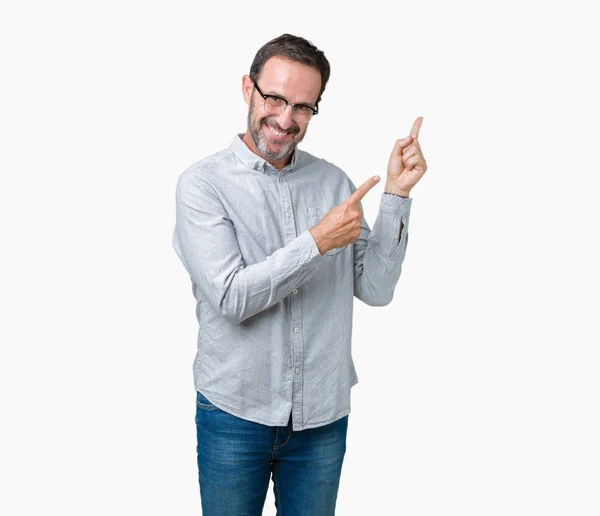 ハンサムな中年眼鏡をかけて笑顔で側に つの手と指で指しているカメラを見て孤立の背景にエレガントな年配の男性 — ストック写真