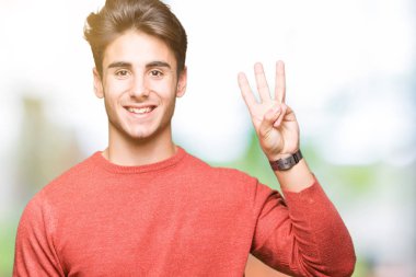 Yakışıklı delikanlı gösterilen ve parmakları ile işaret izole arka plan üzerinde üçüncü ise kendinden emin ve mutlu gülümseyerek.