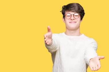 Sarılmak için kollarını açarak gülümseyerek kameraya bakarak izole arka plan üzerinde gözlük takan yakışıklı delikanlı. Neşeli ifade kucaklayan mutluluk.