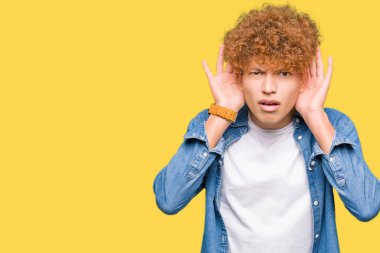 Genç yakışıklı adam ile afro saç giyen denim ceket iki elini de kulak jestinde duymaya çalışıyorum, dedikoduyu merak ediyor. İşitme sorunu, sağır