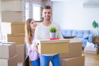 Yeni ev, yeni bir daire için çok mutlu ve neşeli karton kutular tutarak hareket aşk genç güzel çift