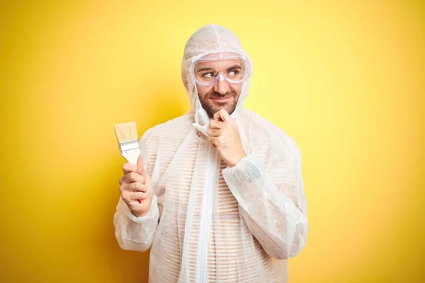 Joven Usando Equipo Pintor Sosteniendo Pincel Pintura Sobre Fondo Amarillo — Foto de Stock