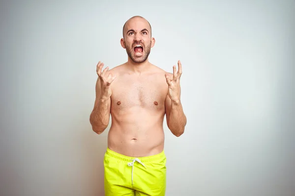 셔츠없는 남자는 배경에 노란색 수영복을 소리와 공격적인 표정과 — 스톡 사진