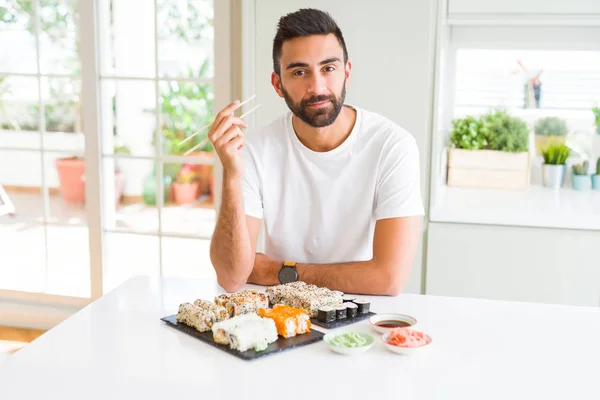 Przystojny Hiszpan Jedzenia Asian Sushi Pomocą Pałeczek Pewnym Wyrażeniem Inteligentne — Zdjęcie stockowe