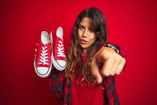 Mujer Hermosa Joven Sosteniendo Zapatillas Pie Sobre Fondo Rojo Aislado —  Fotos de Stock