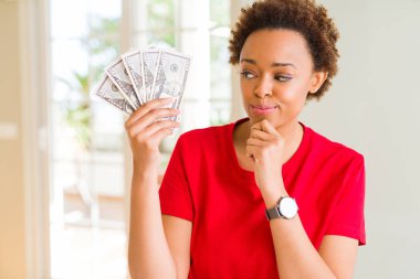 Genç afro-amerikan kadın elli dolar ciddi yüz soru hakkında düşünme banka notları tutan, çok karışık bir fikir
