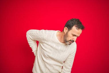 İzole kırmızı arka plan üzerinde gri saçlı yakışıklı Orta Çağ kıdemli adam sırt ağrısı acı, el ile geri dokunmadan, kas ağrısı