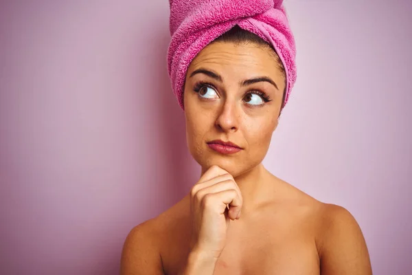 年轻美女穿毛巾淋浴后 孤立的粉红色背景严肃面对思考问题 非常困惑的想法 — 图库照片