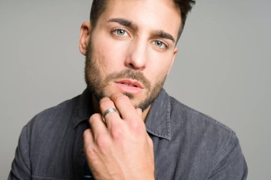 Yakışıklı delikanlı possing ve modelleme gri izole backg üzerinde