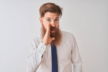 Gizli söylenti söyleyerek izole beyaz arka plan el üzerinde ayakta genç Redhead İrlandalı işadamı, kötü niyetli konuşma konuşma fısıldayan