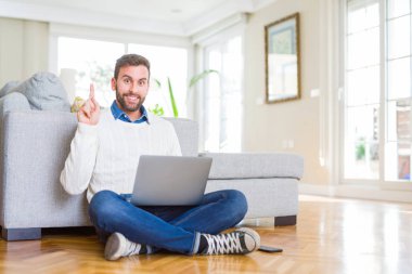 Yakışıklı adam bilgisayar laptop kullanarak çalışma giyen bir fikir veya soru mutlu yüz, bir numara ile parmak işaret ile şaşırttı